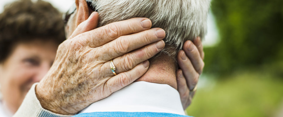 An elderly couple embracing